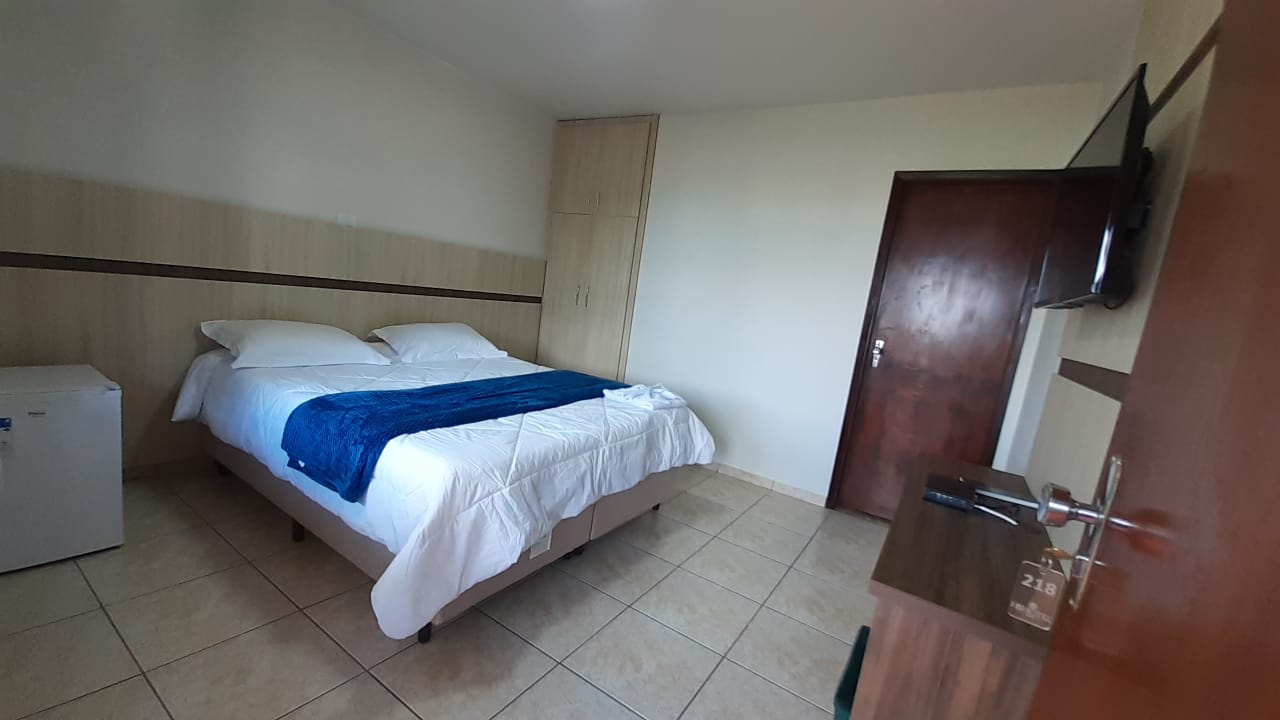 Quarto de casal com frigobar e televisão
