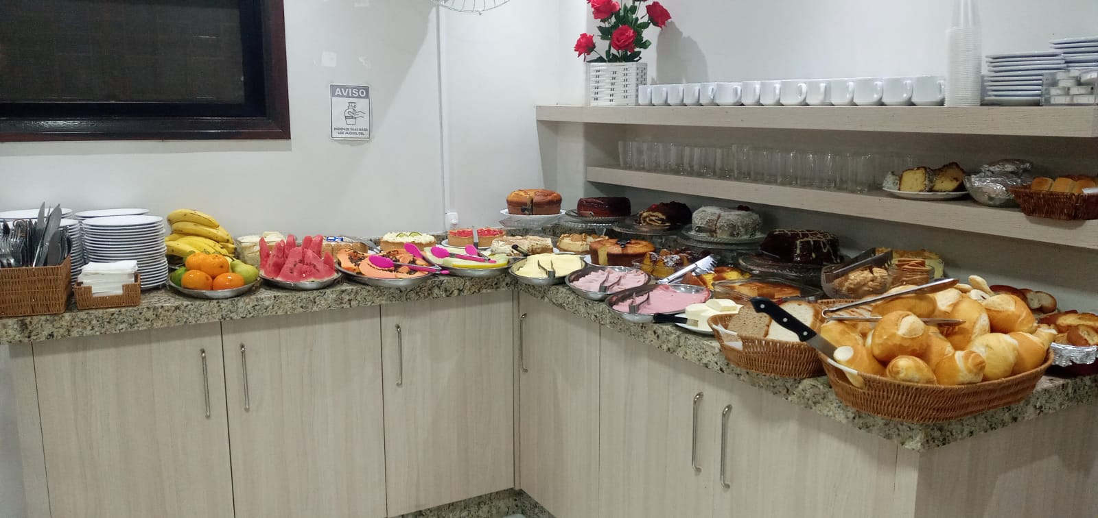 Buffet completo com frutas, pães, frios e bolos