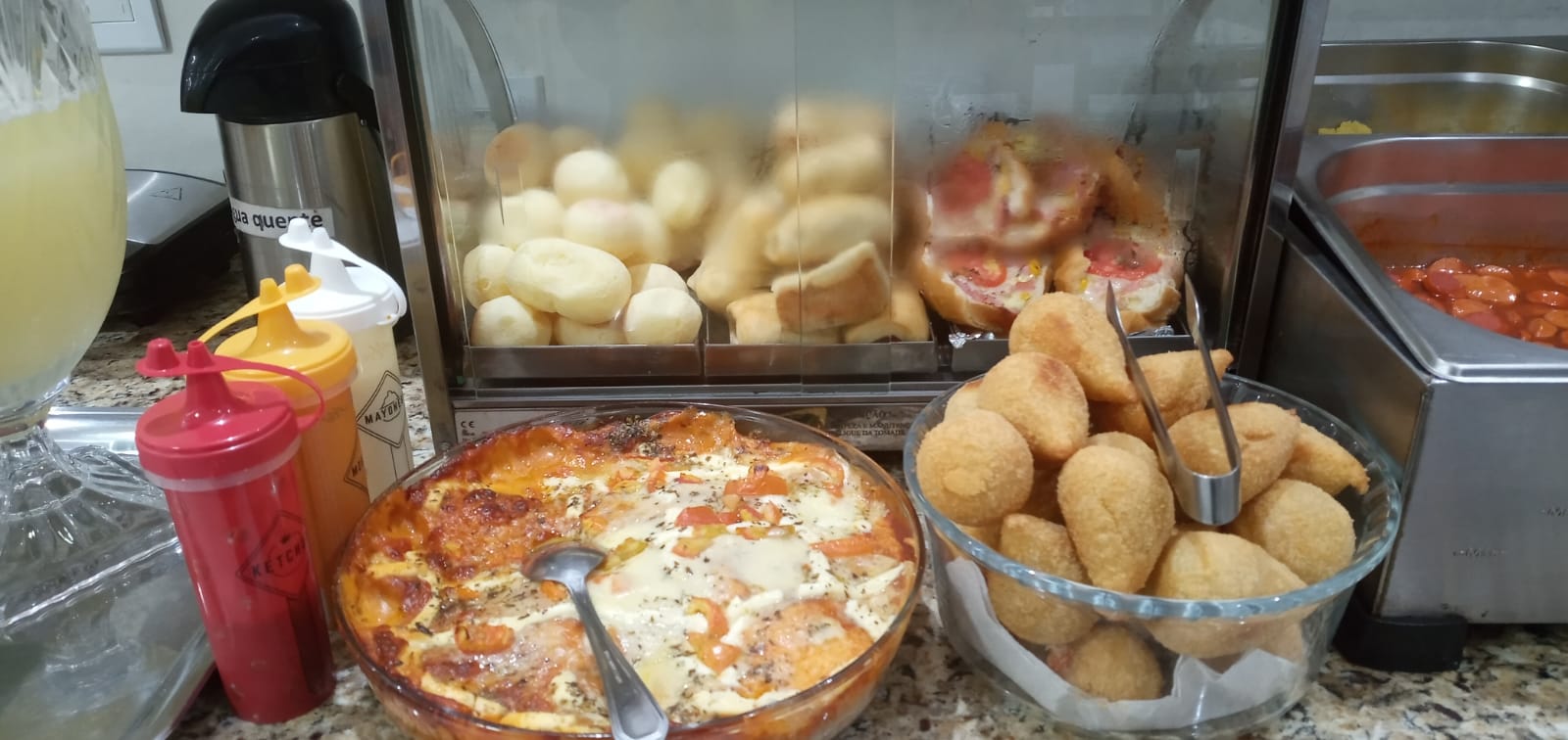 Pães de queijo, salgados e torta no buffet do hotel