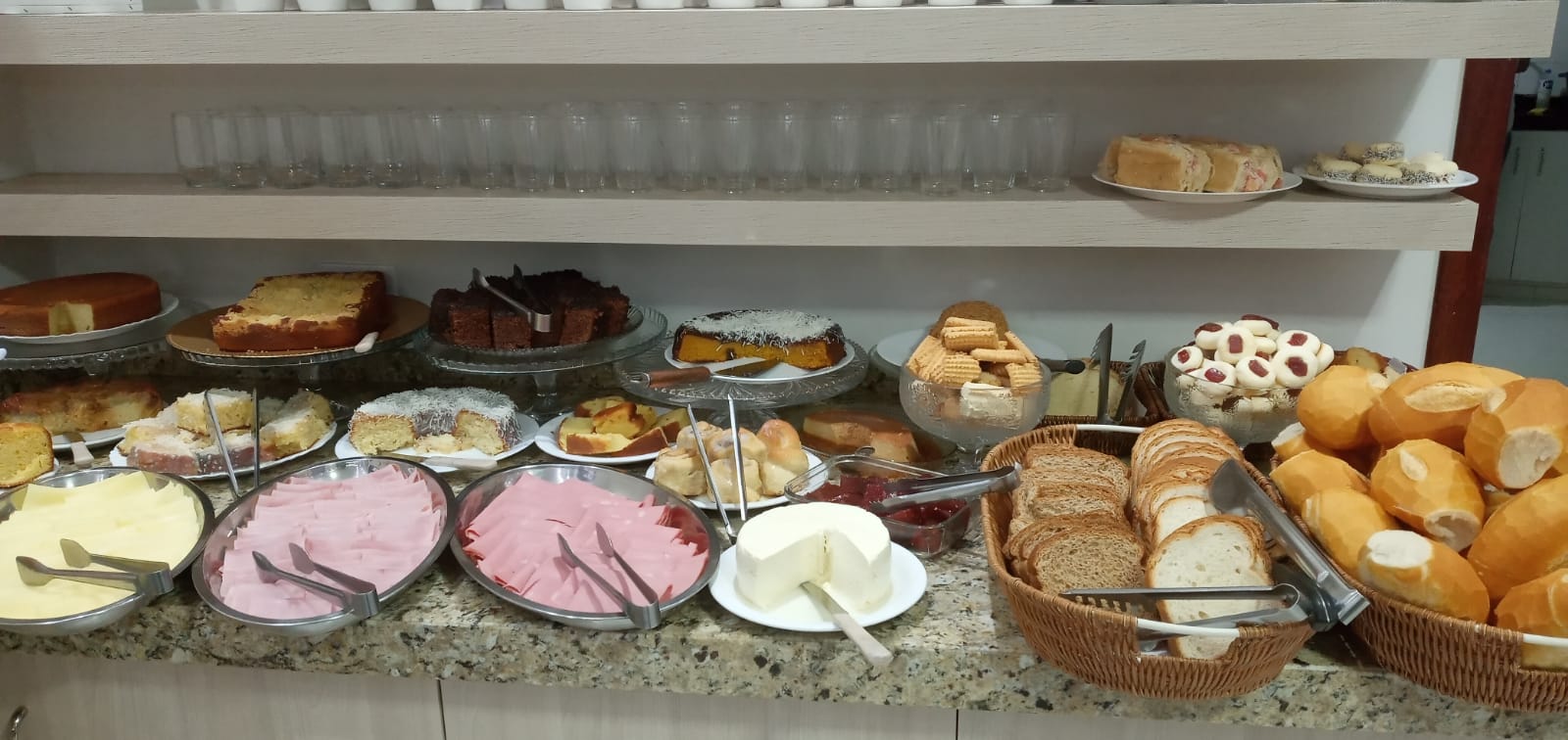 Pães, bolos, frios e queijo no buffet do hotel